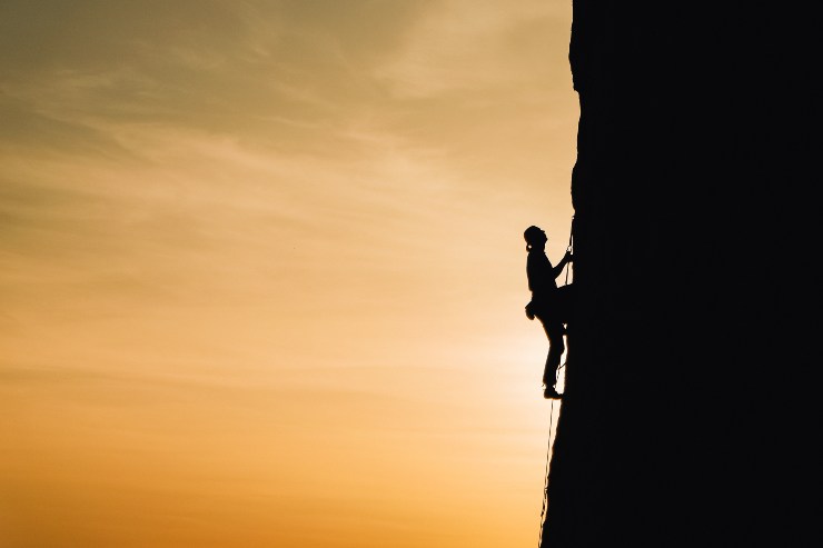 Persona coraggiosa che scala la montagna